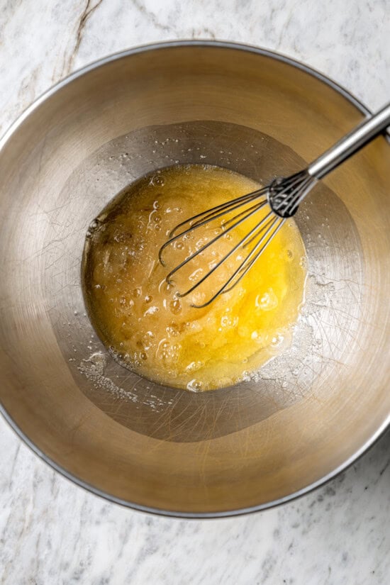 Light and airy peppermint meringues are the perfect addition to any holiday cookie tray! They're surprisingly easy to make and always a hit. Whisking egg and sugar in bowl on stove