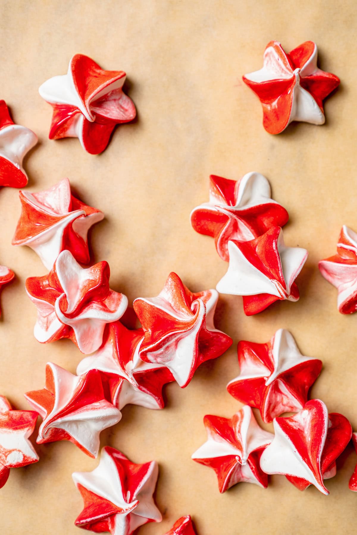 Light and airy peppermint meringues are the perfect addition to any holiday cookie tray! They're surprisingly easy to make and always a hit. Overhead view of peppermint meringues on parchment paper