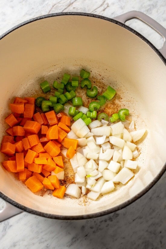 Carrots, onion, and celery cooking in Dutch oven