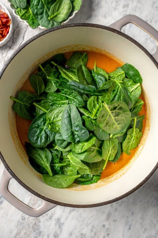 Baby spinach added to pot of navy bean soup