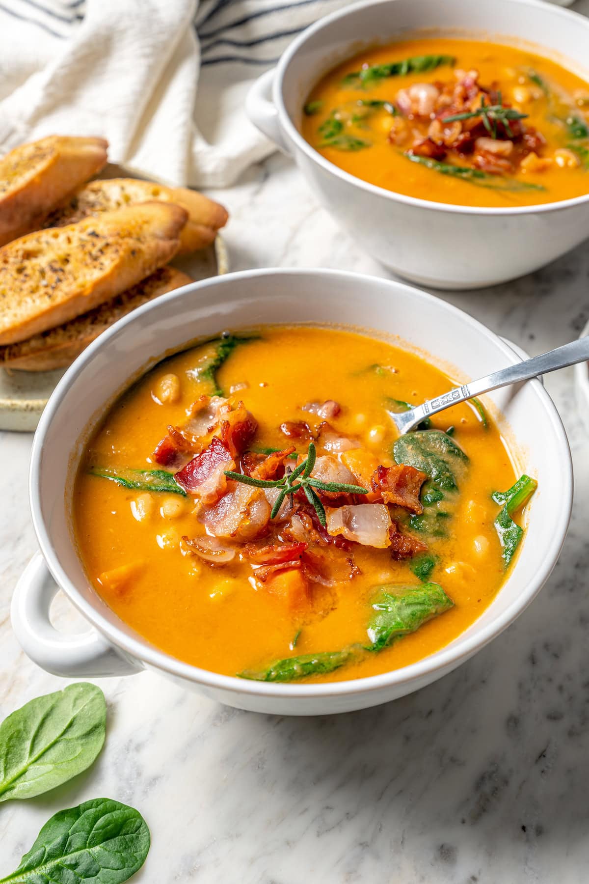 Bowl of navy bean soup with bacon on top