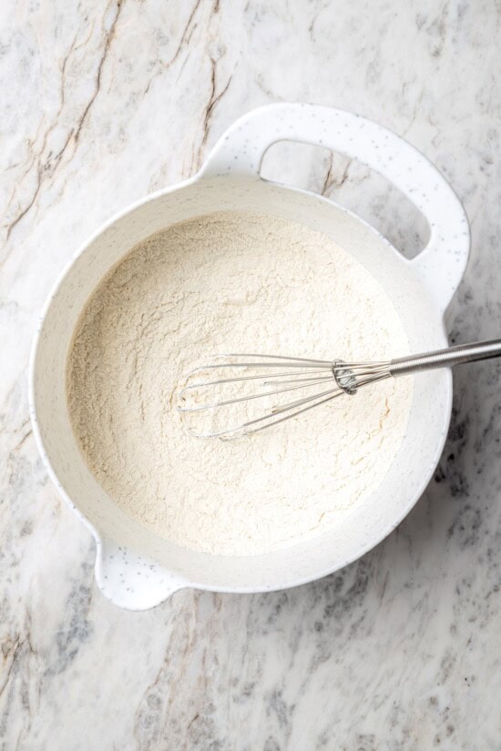 Overhead view of dry ingredients in mixing bowl with whisk