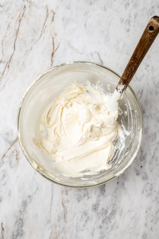 Overhead view of cream cheese frosting in glass bowl