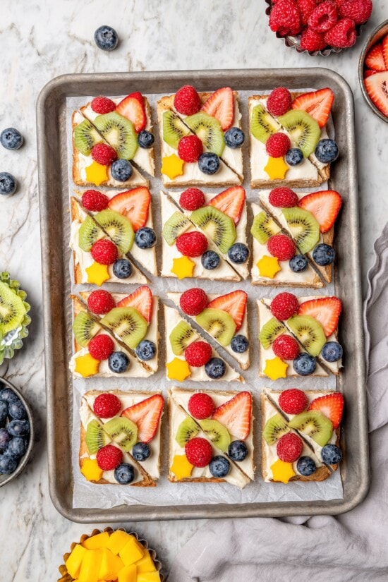 Overhead view of sugar cookie fruit pizza on sheet pan
