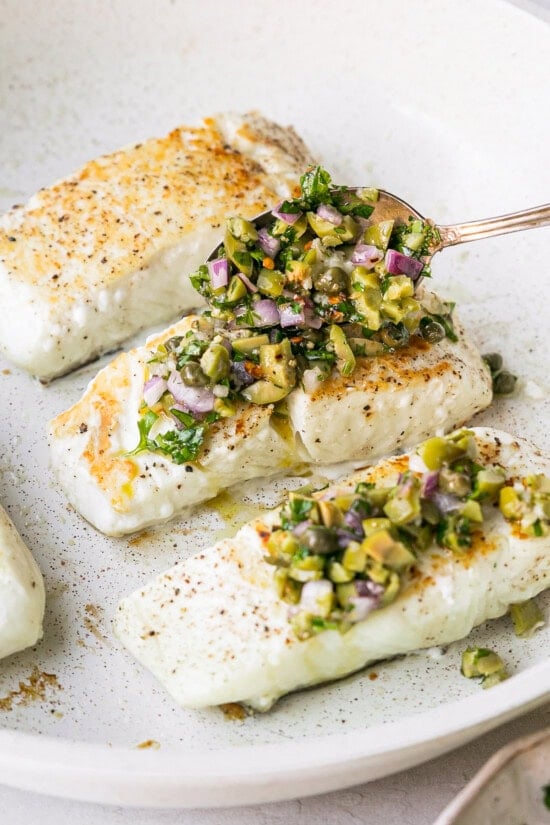 spoon olive chimichurri over fish