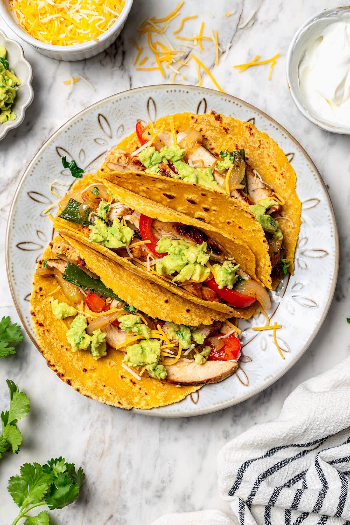 Overhead view of chicken fajitas in tortillas on plate