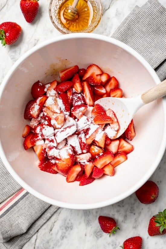 Stirring cornstarch into strawberries in bowl