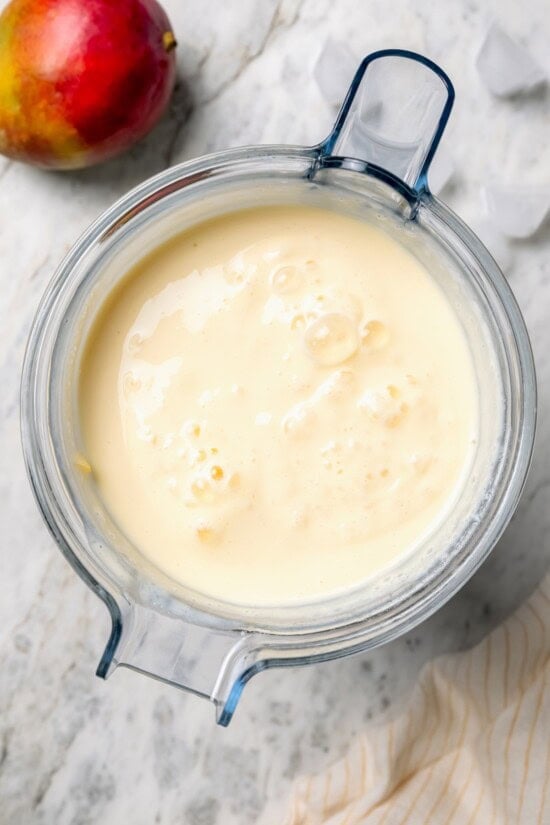 Overhead view of mango lassi in blender
