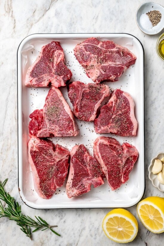 Overhead view of seasoned lamb chops in pan