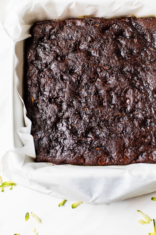 Overhead view of zucchini brownies in parchment-lined pan
