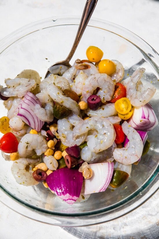 Shrimp, tomatoes, olives, onion in a bowl