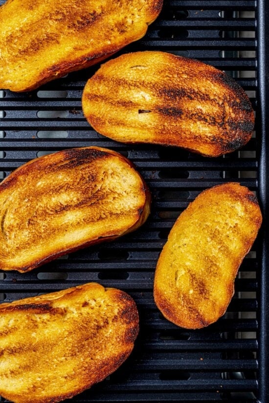 Overhead view of bread slices toasting on indoor grill