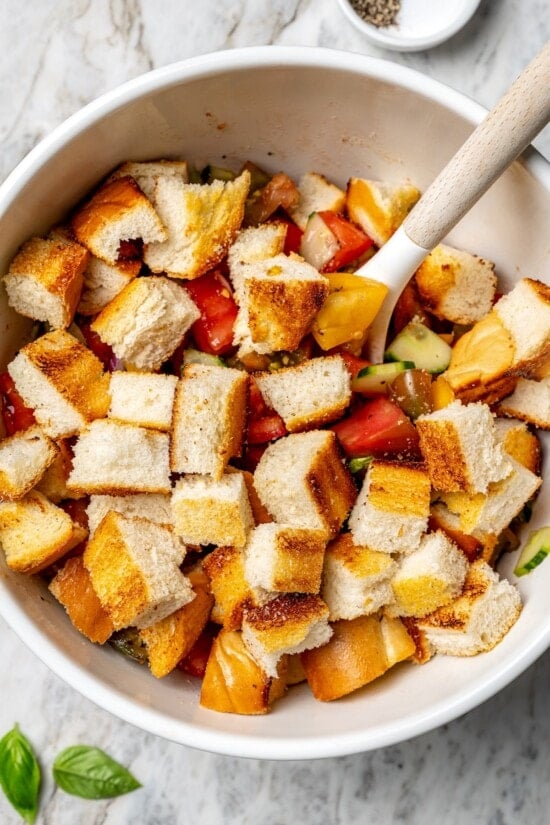 Stirring bread into bowl of panzanella