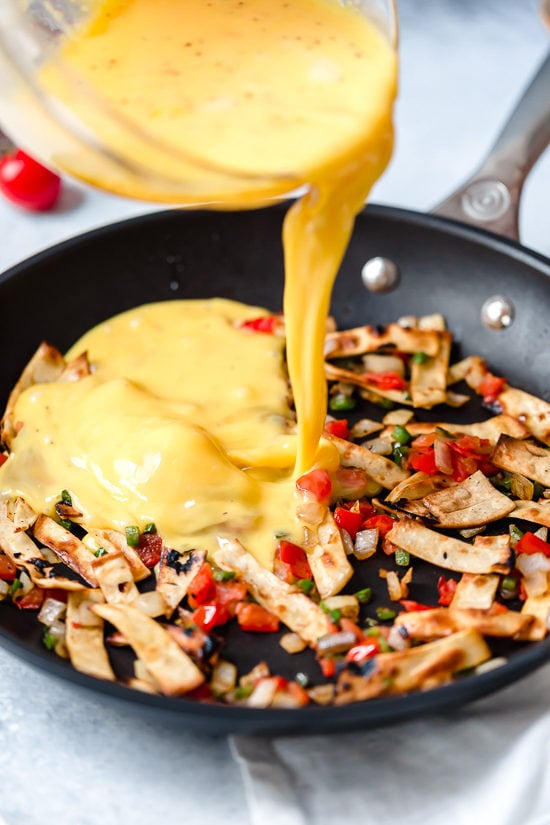 Pouring egg into pan for migas