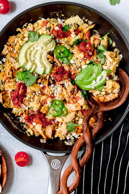 Overhead view of Tex Mex migas in skillet with sliced avocado