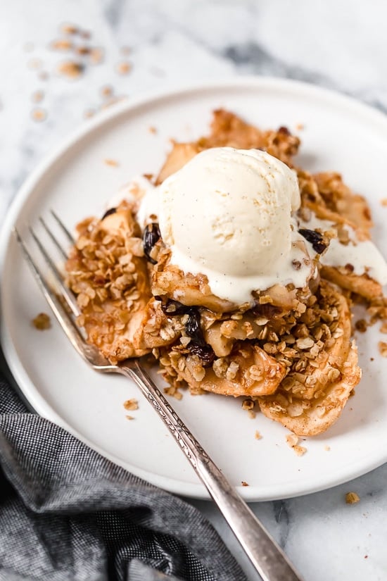 Cinnamon apple crisp recipe made with honey, oats, and baked apples topped with ice cream.