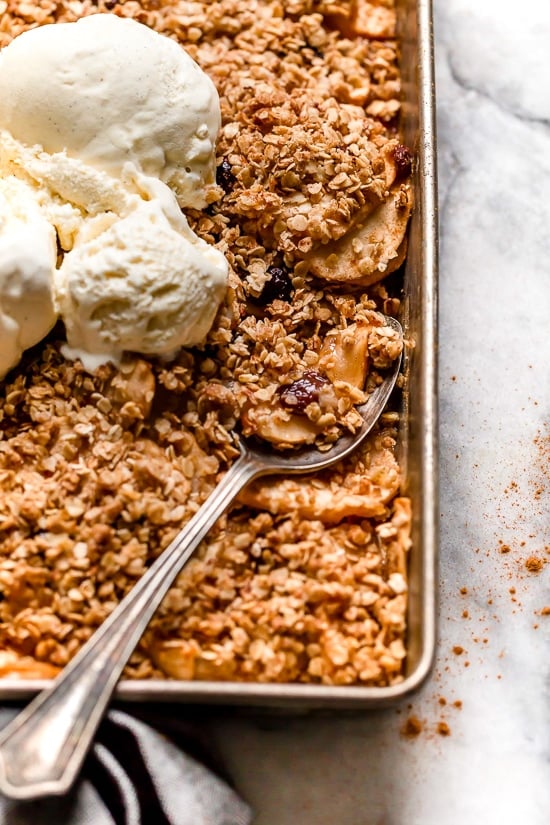 Golden brown apple crisp baked with oat topping and vanilla ice cream on top