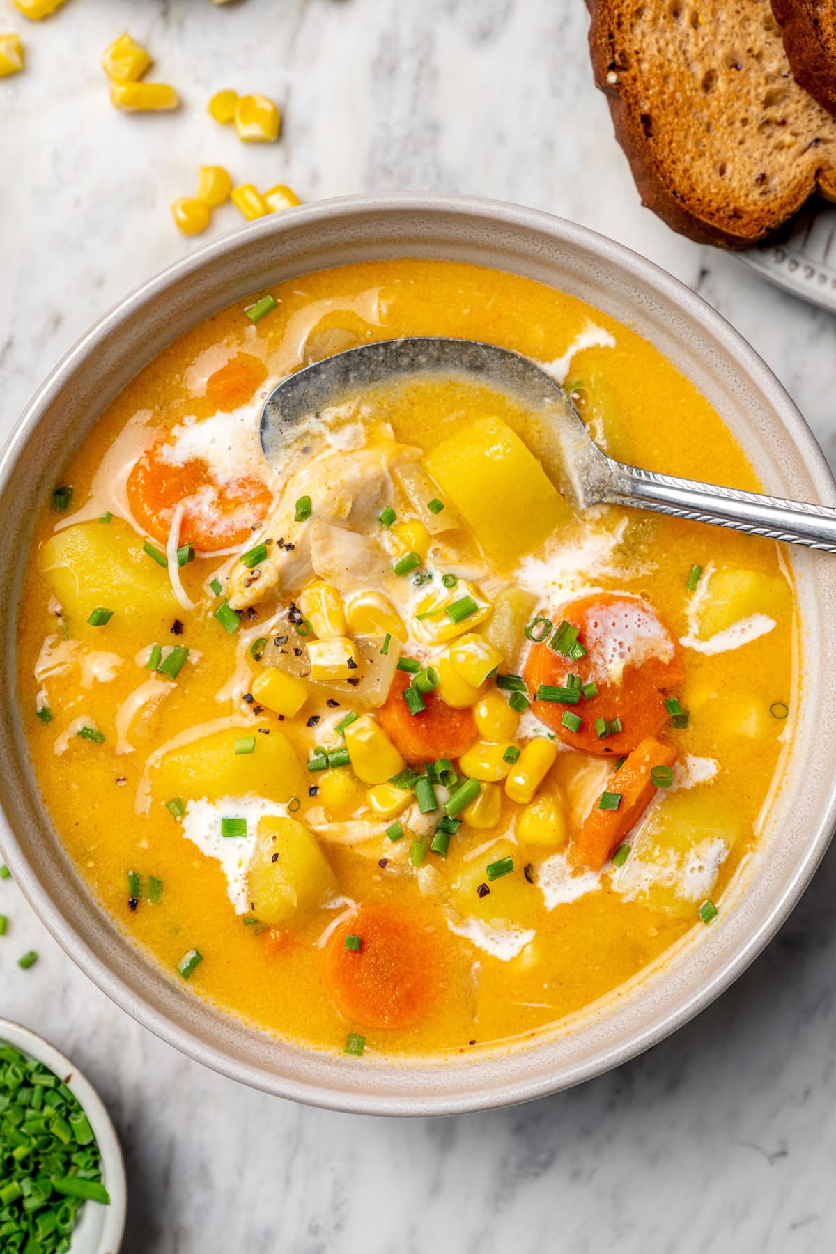 This rich, creamy Chicken Corn Chowder is thickened with potatoes and pureed corn instead of heavy cream to keep it light. Easy and delicious! Chicken corn chowder in bowl with spoon.