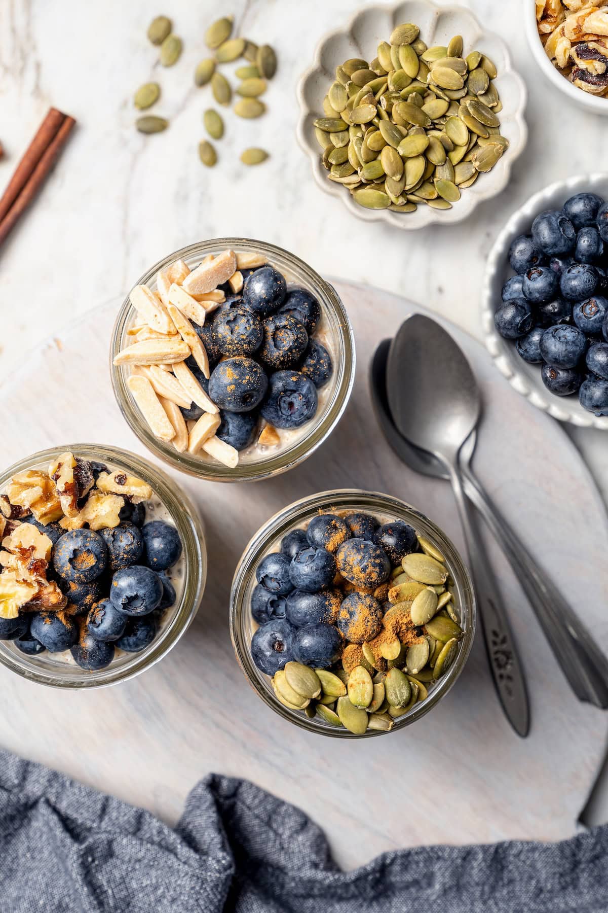 Overhead view of overnight oats topped with blueberries, nuts, and pepitas