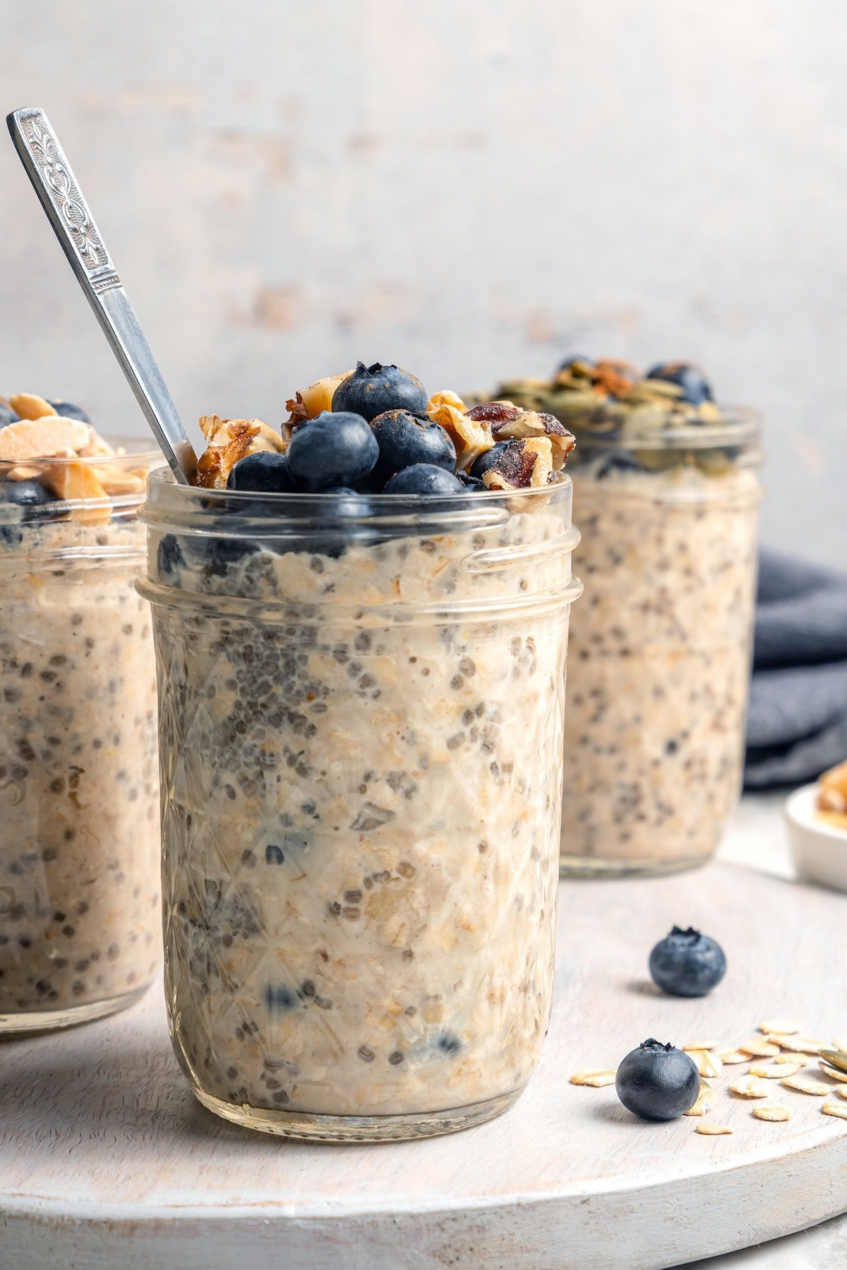 3 jars of overnight oats topped with blueberries and walnuts