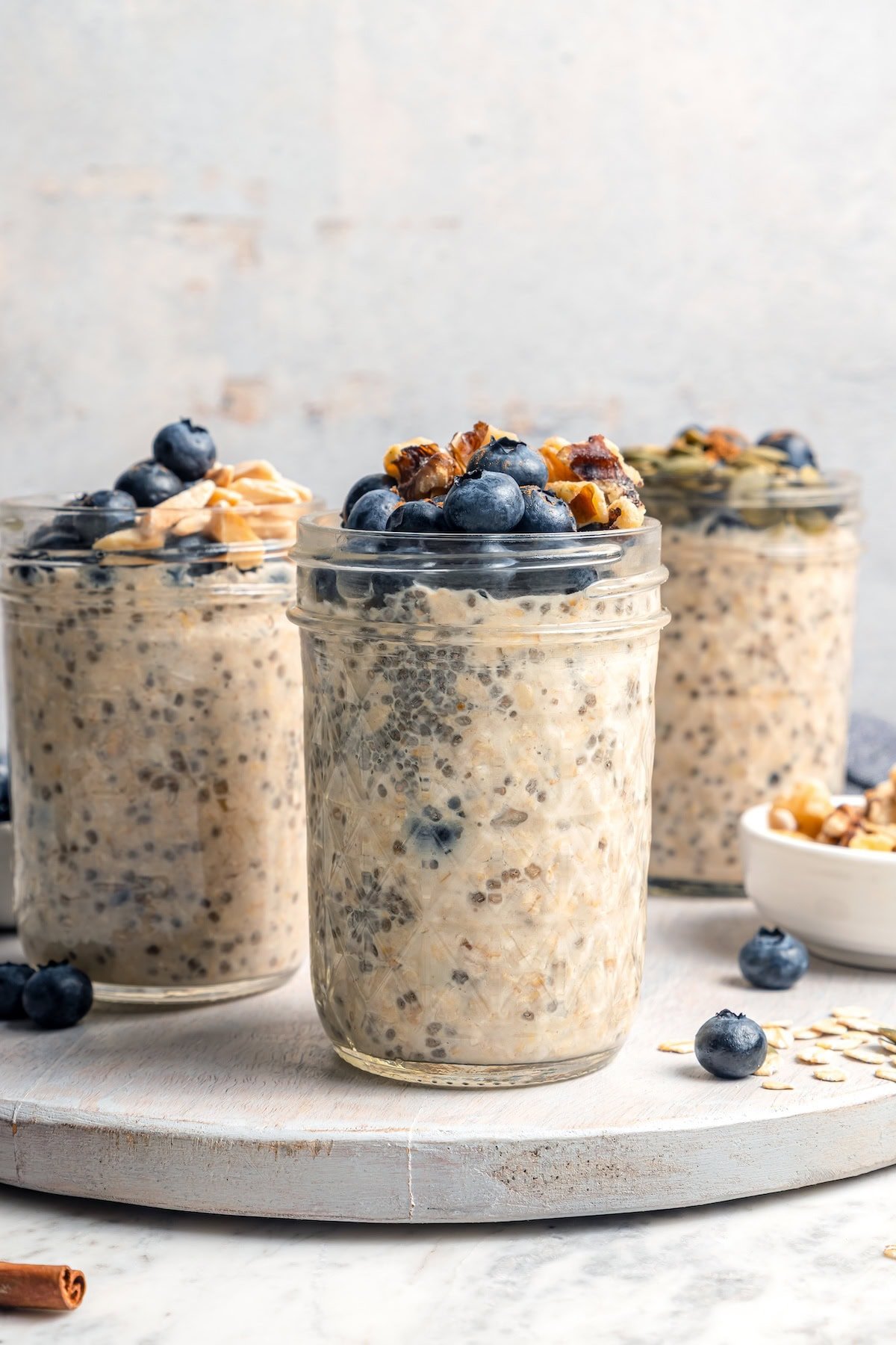 3 jars of overnight oats topped with blueberries and walnuts