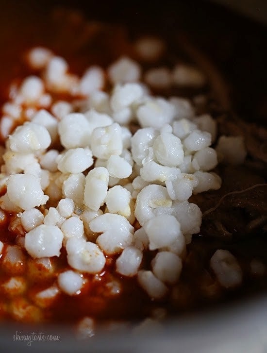 Hominy added to pozole rojo.