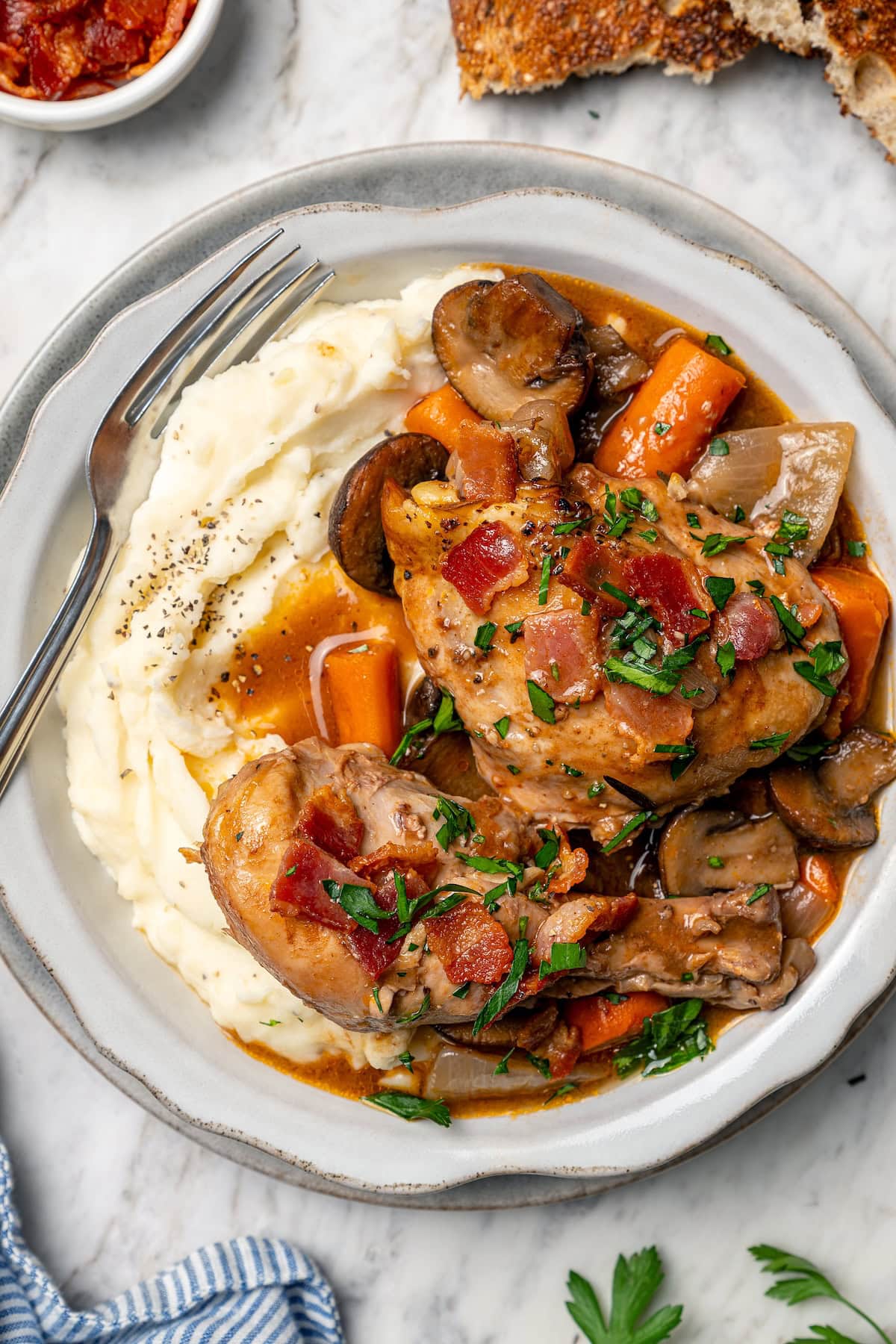 Crockpot coq au vin served over mashed potatoes.