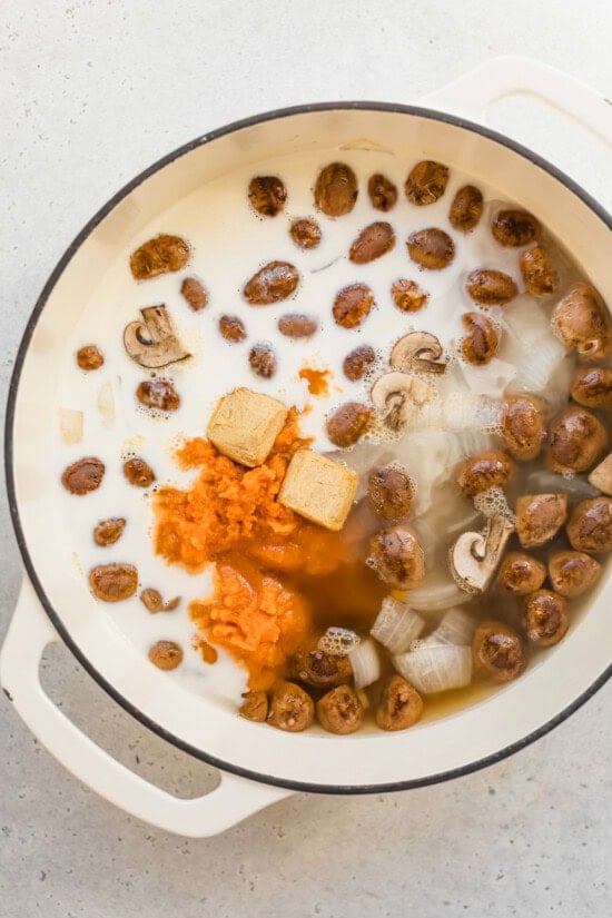 Ingredients in a pot for pumpkin soup with canned pumpkin, ginger, and coconut milk