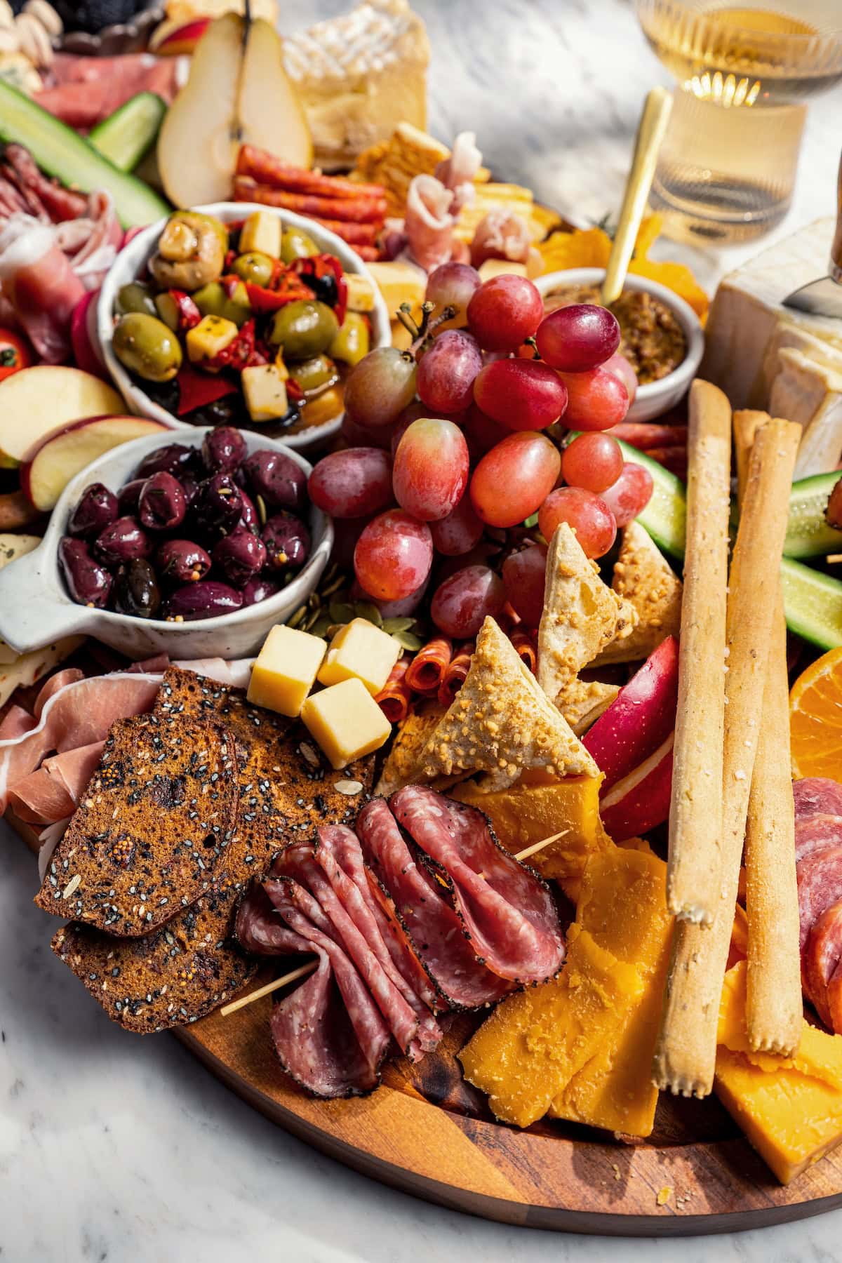 Charcuterie board with cheese, meat, fruit, olives, and more.
