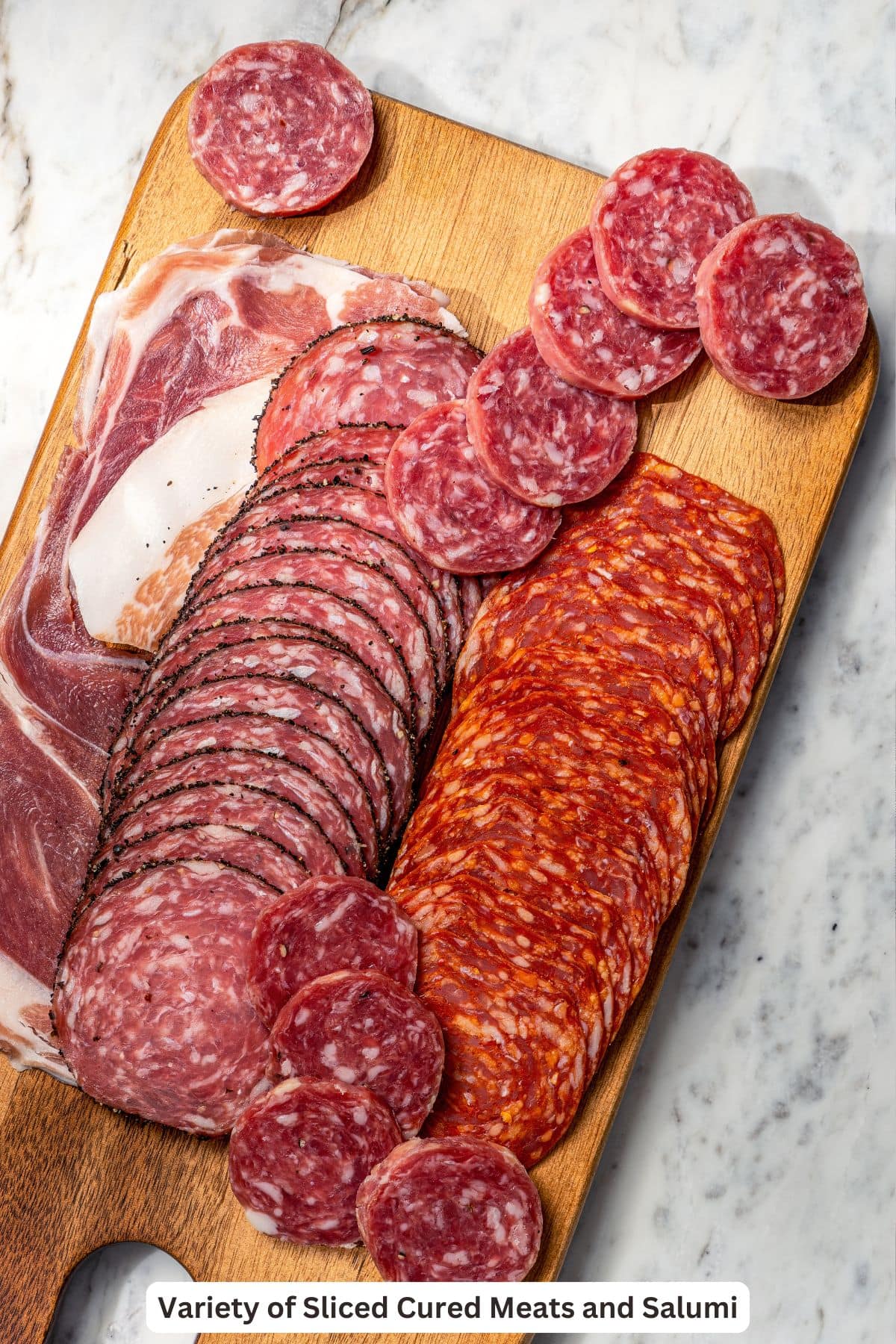 Cured meats and salami on wooden board.