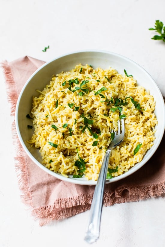 Rice pilaf in bowl with parsley for garnish.