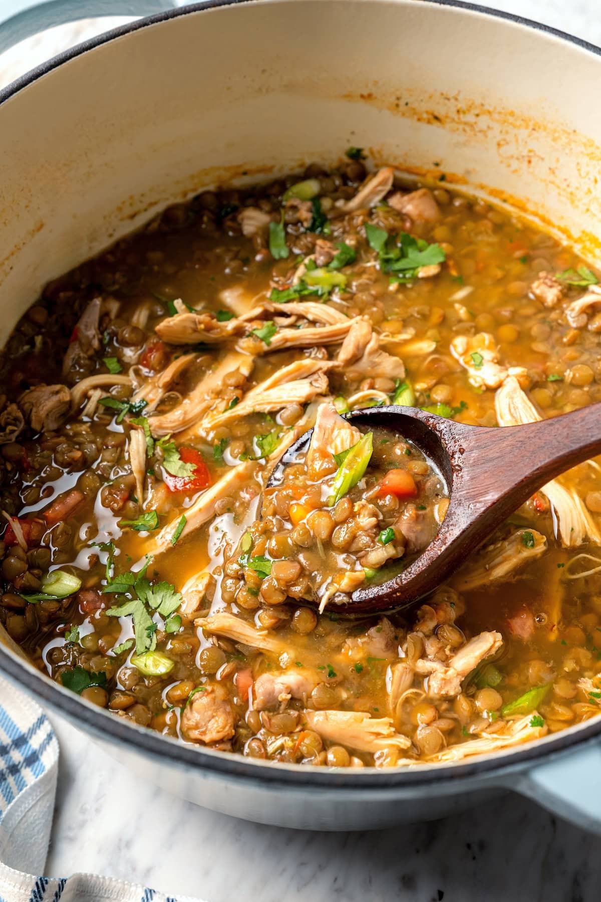 Ladling chicken lentil soup from Dutch oven.