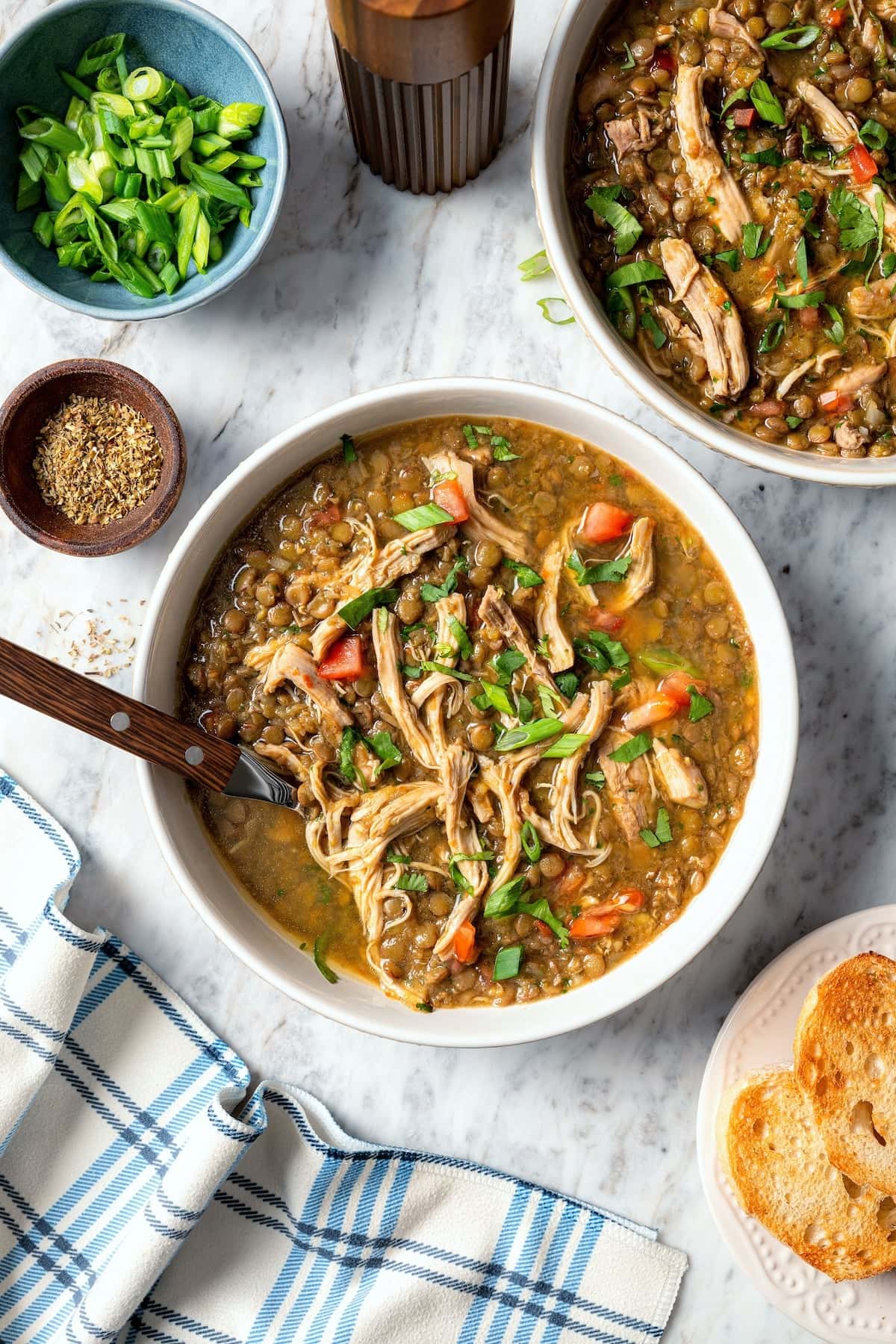 Two bowls of chicken lentil soup with cilantro.