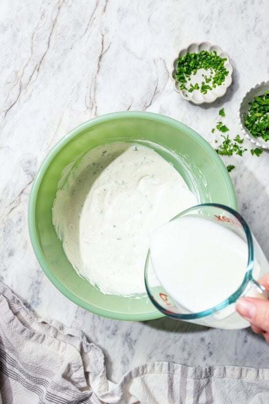 Pouring buttermilk into bowl for ranch dressing.