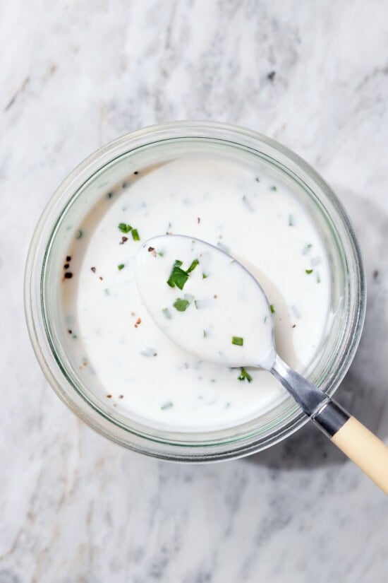 Spoonful of buttermilk ranch dressing set in bowl.