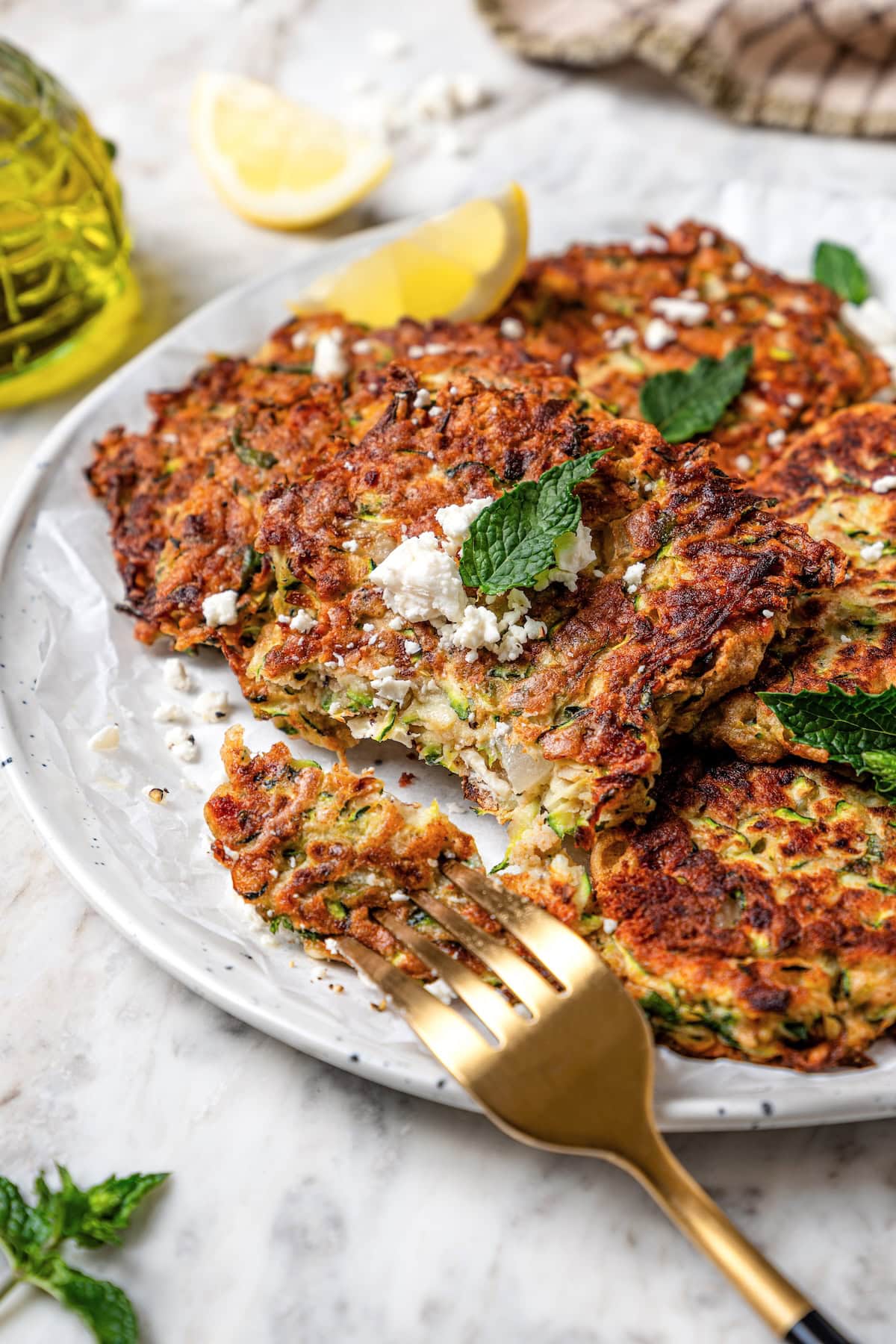 Zucchini fritters on plate with fork.