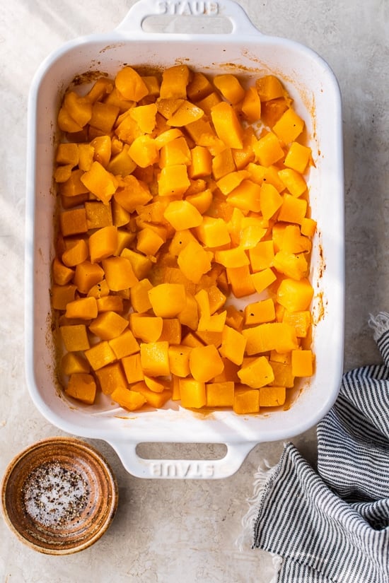 This easy maple roasted butternut squash is a quick fall side dish with cubed squash tossed in pure maple syrup. Perfect for holiday dinners! Maple roasted butternut squash in a casserole dish.