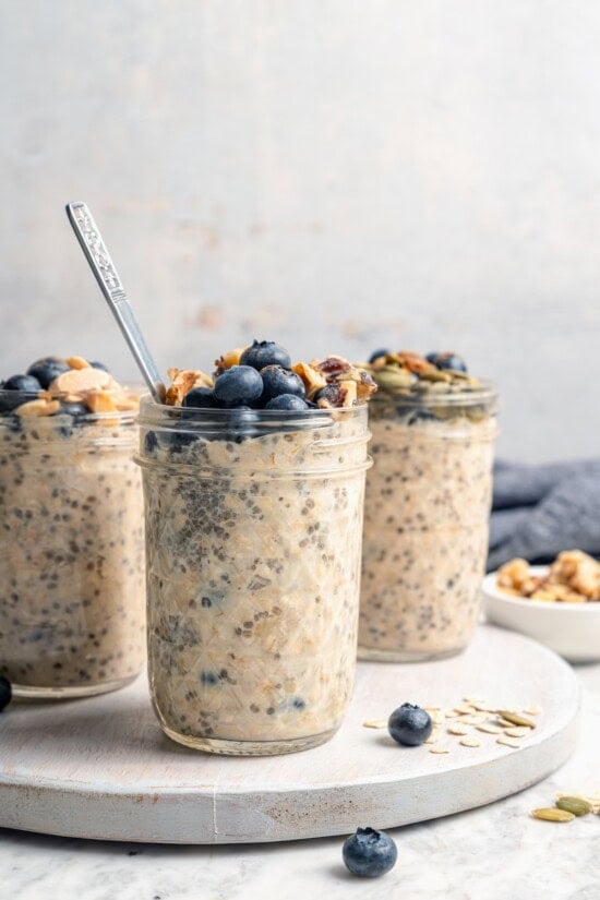 3 jars of overnight oats topped with blueberries and walnuts