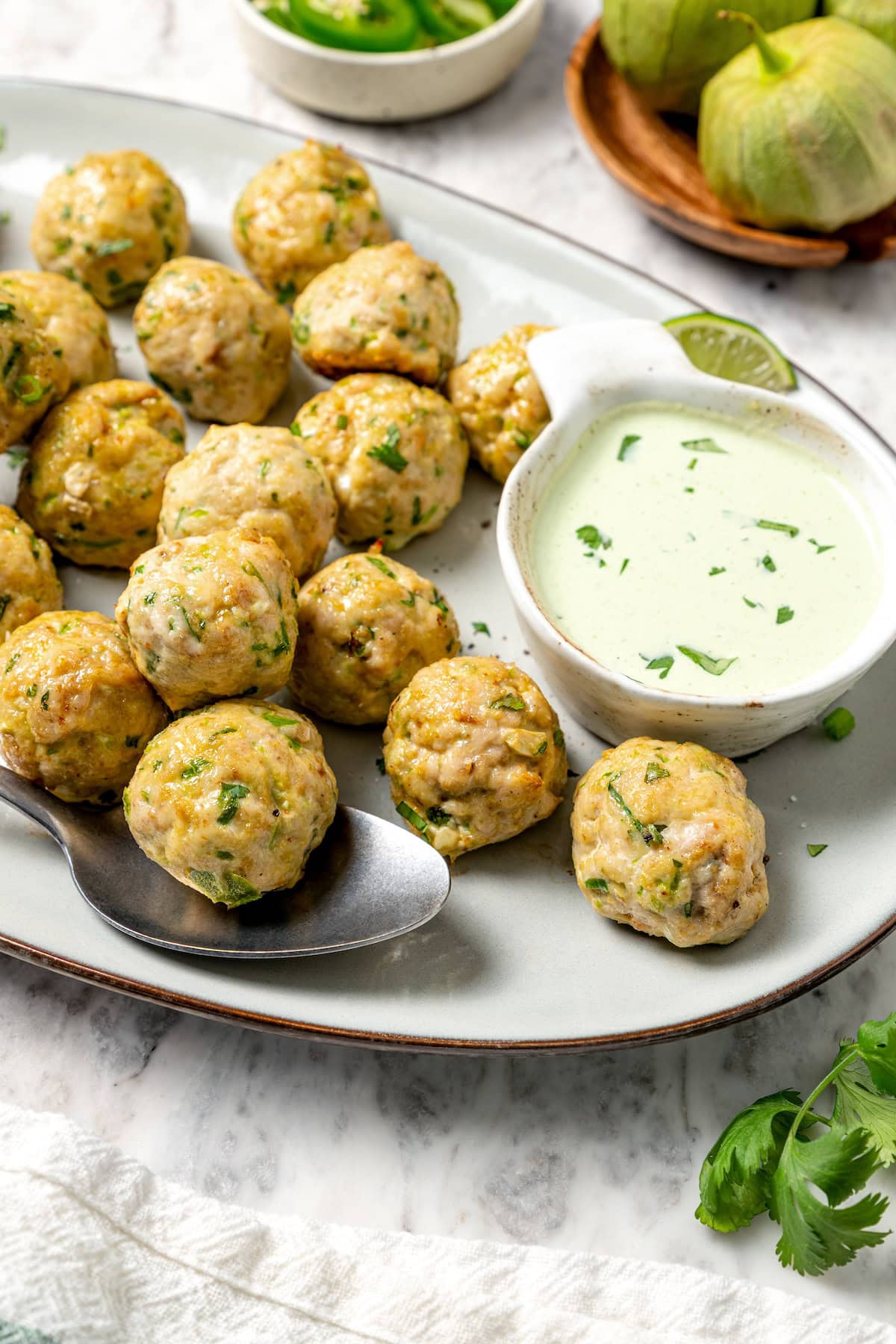 Platter of baked southwest turkey meatballs with bowl of creamy dipping sauce.